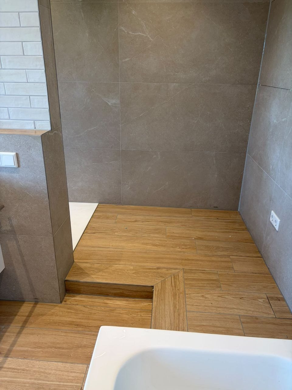 Übergang vom Holzoptik-Boden zur Dusche, Podest mit sauber gearbeiteter Stufenkante